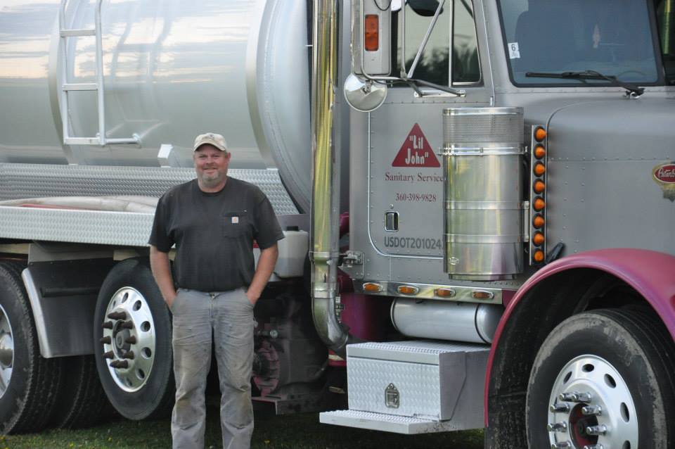 Mark from Lil John Sanitary Services standing next to a commercial septic tank pumping truck in Sedro-Woolley, WA.