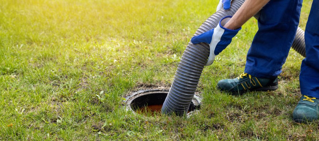 worker pumping septic tank | 6 signs your septic tank needs pumping